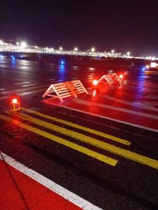 AES-AL-UA-R solar LED unserviceable area lights illuminated at night on Dublin Airport Runway 16-34 with safety barriers