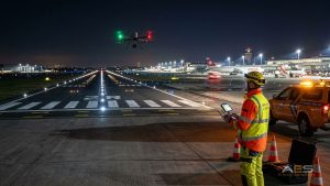 Airfield worker flying a drone with remote controller