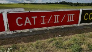 Red mandatory instruction sign with white runway designation numbers at a runway holding position on an airport taxiway